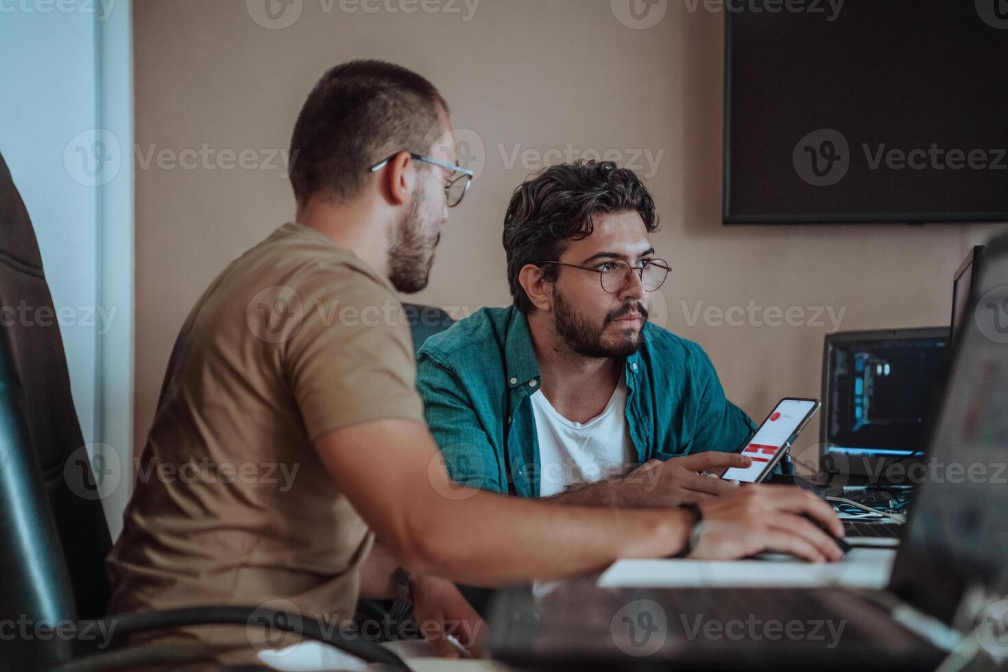 Programmers engrossed in deep collaboration, diligently working together to solve complex problems and develop innovative mobile applications with seamless functionality. photo