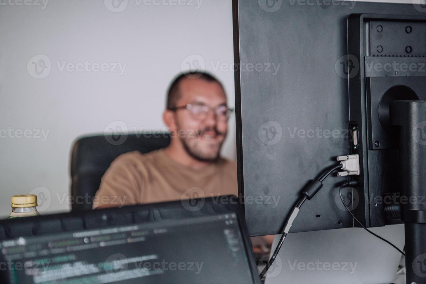 A programmer diligently testing smartphone applications while sitting in their office. photo