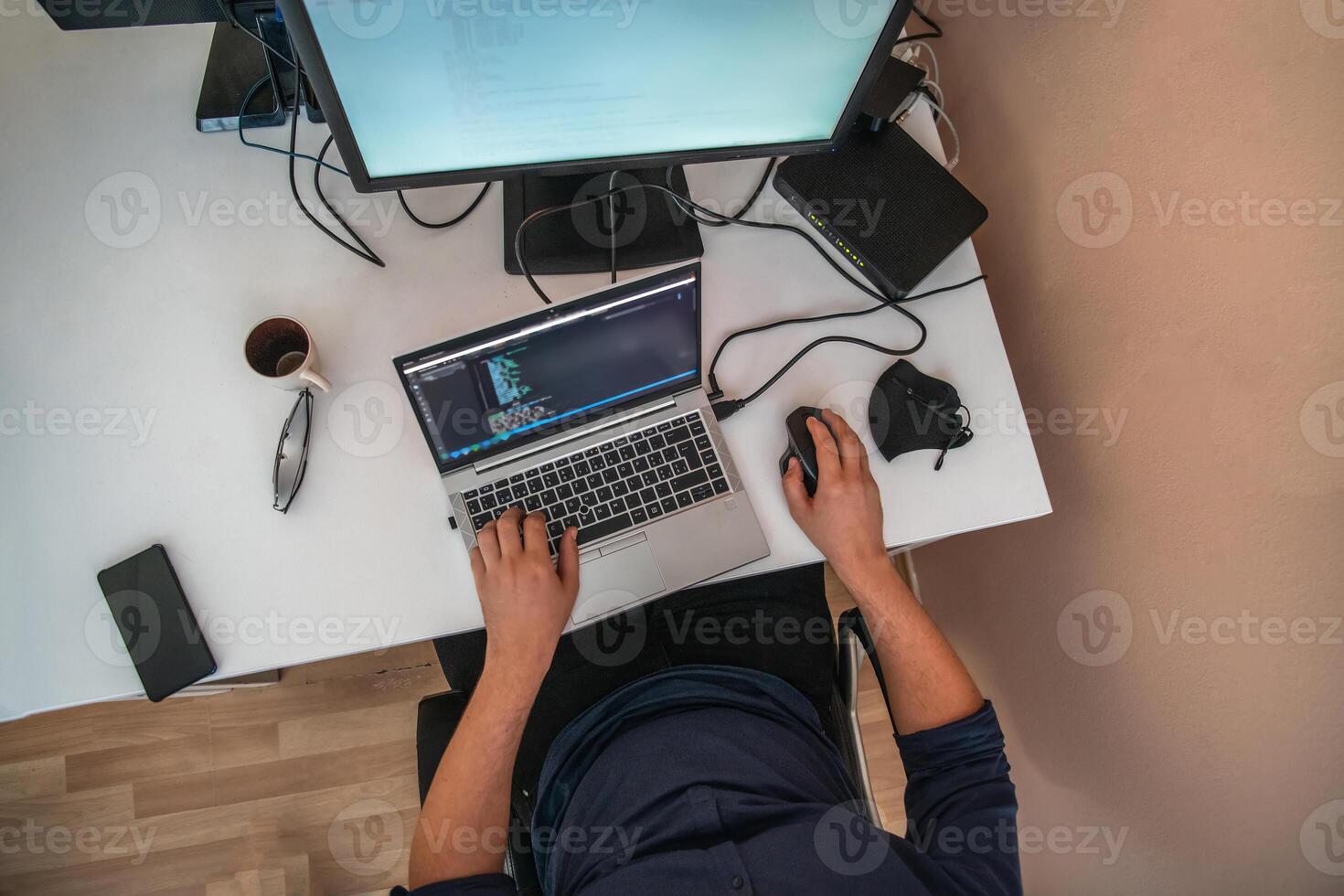 Top view of programmer diligently testing smartphone applications while sitting in their office. photo