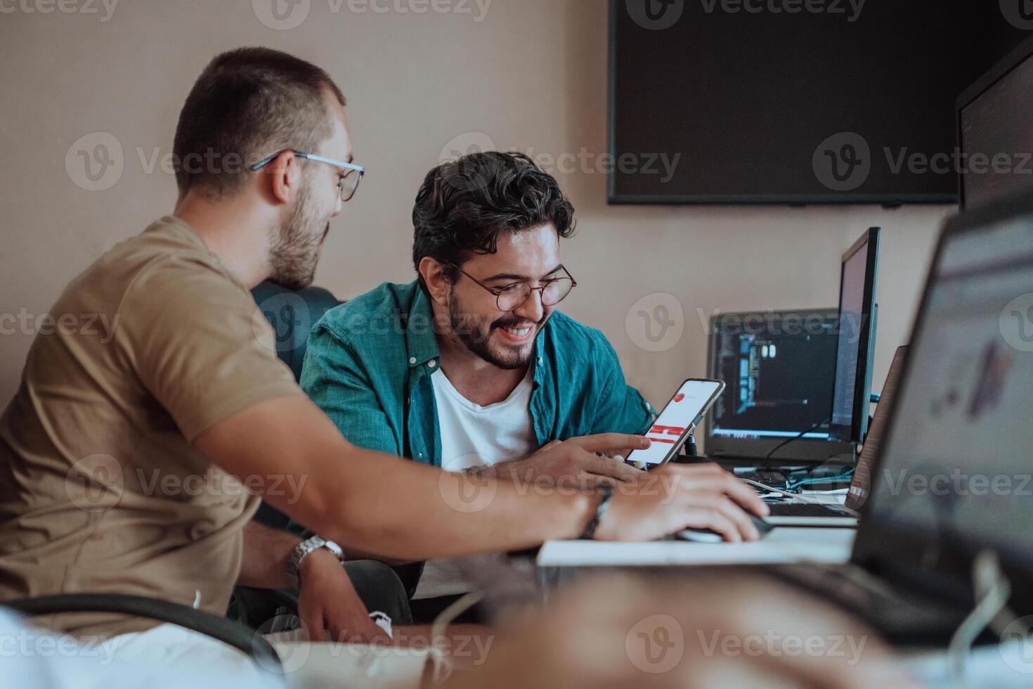 Programmers engrossed in deep collaboration, diligently working together to solve complex problems and develop innovative mobile applications with seamless functionality. photo