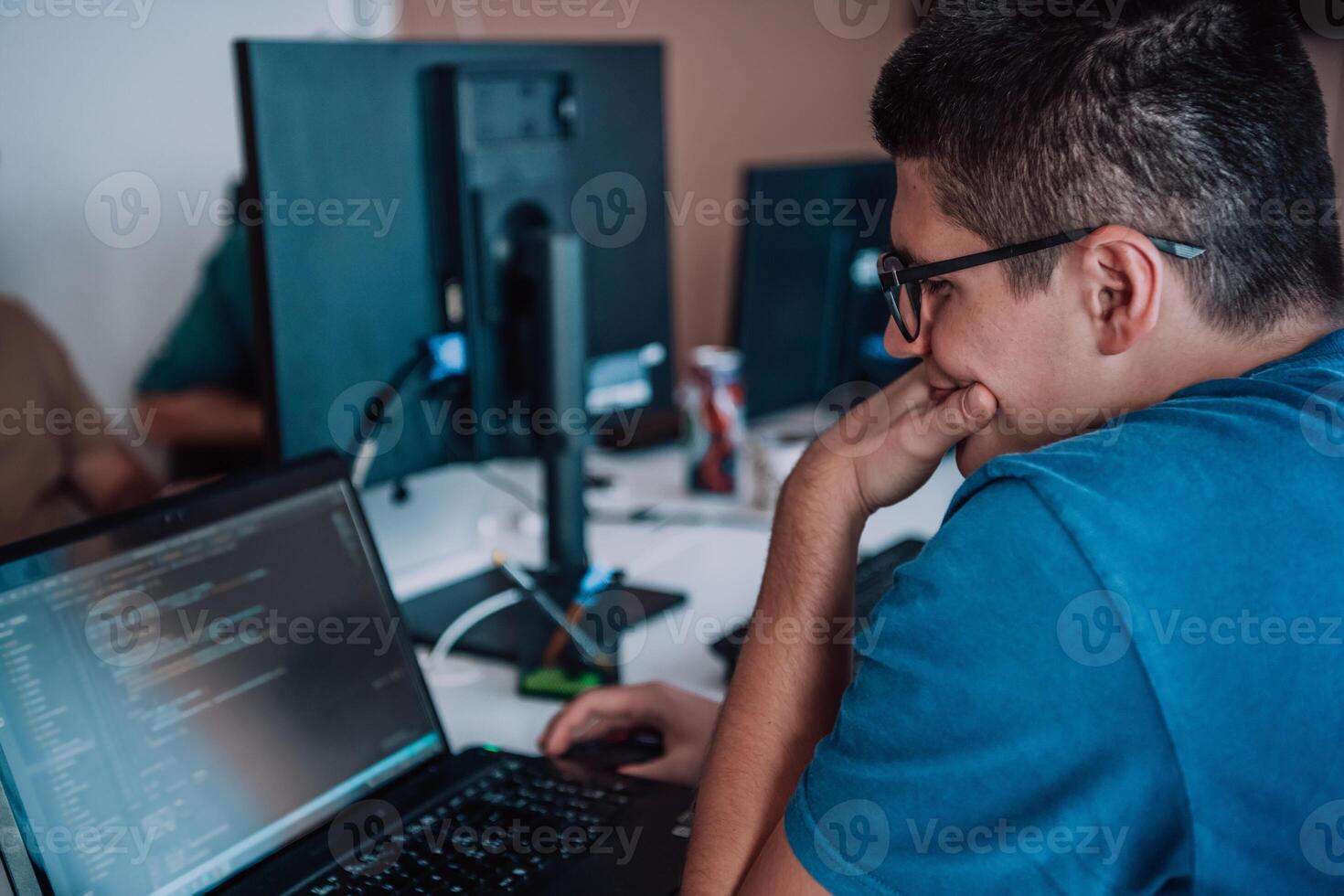 A programmer diligently testing smartphone applications while sitting in their office. photo