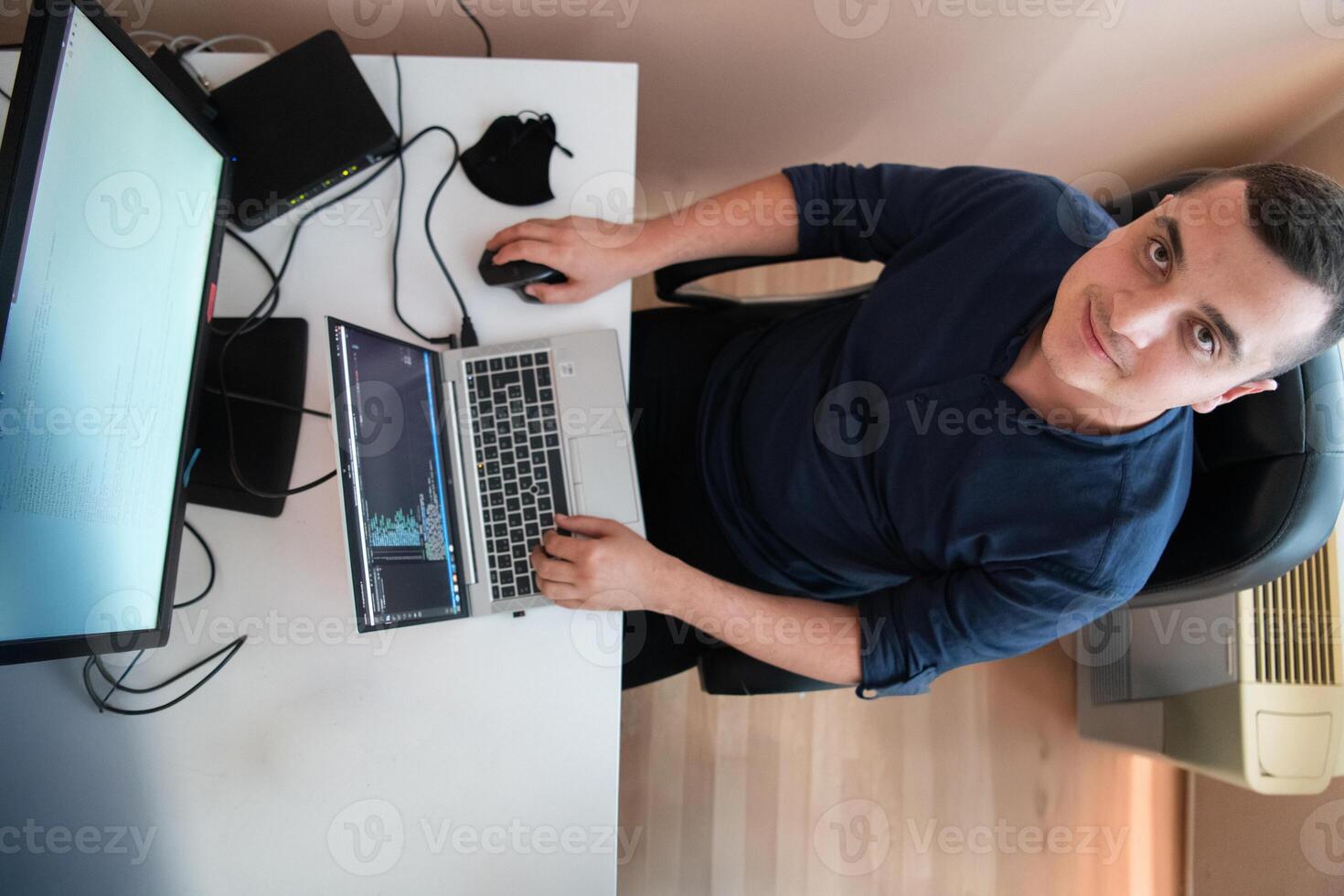 Top view of programmer diligently testing smartphone applications while sitting in their office. photo