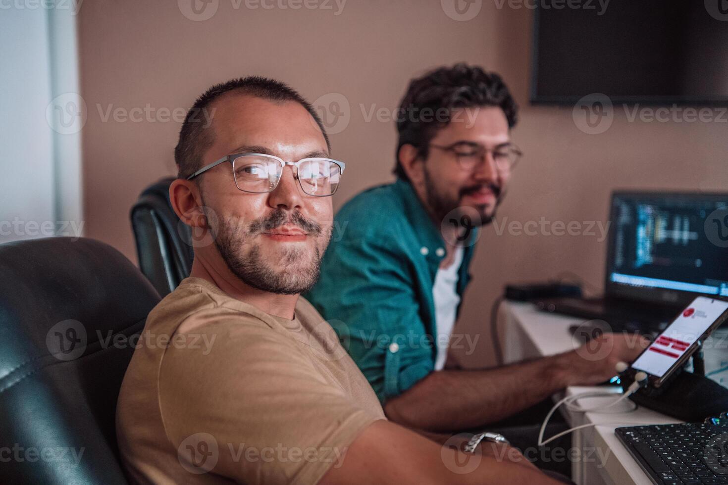 Programmers engrossed in deep collaboration, diligently working together to solve complex problems and develop innovative mobile applications with seamless functionality. photo
