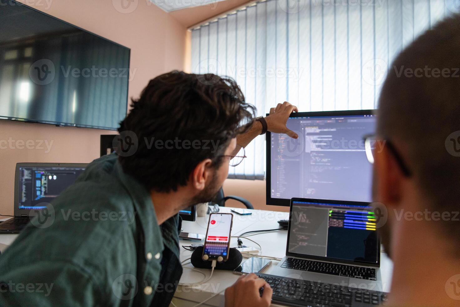 Programmers engrossed in deep collaboration, diligently working together to solve complex problems and develop innovative mobile applications with seamless functionality. photo
