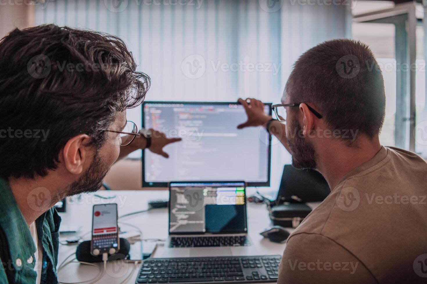 Programmers engrossed in deep collaboration, diligently working together to solve complex problems and develop innovative mobile applications with seamless functionality. photo