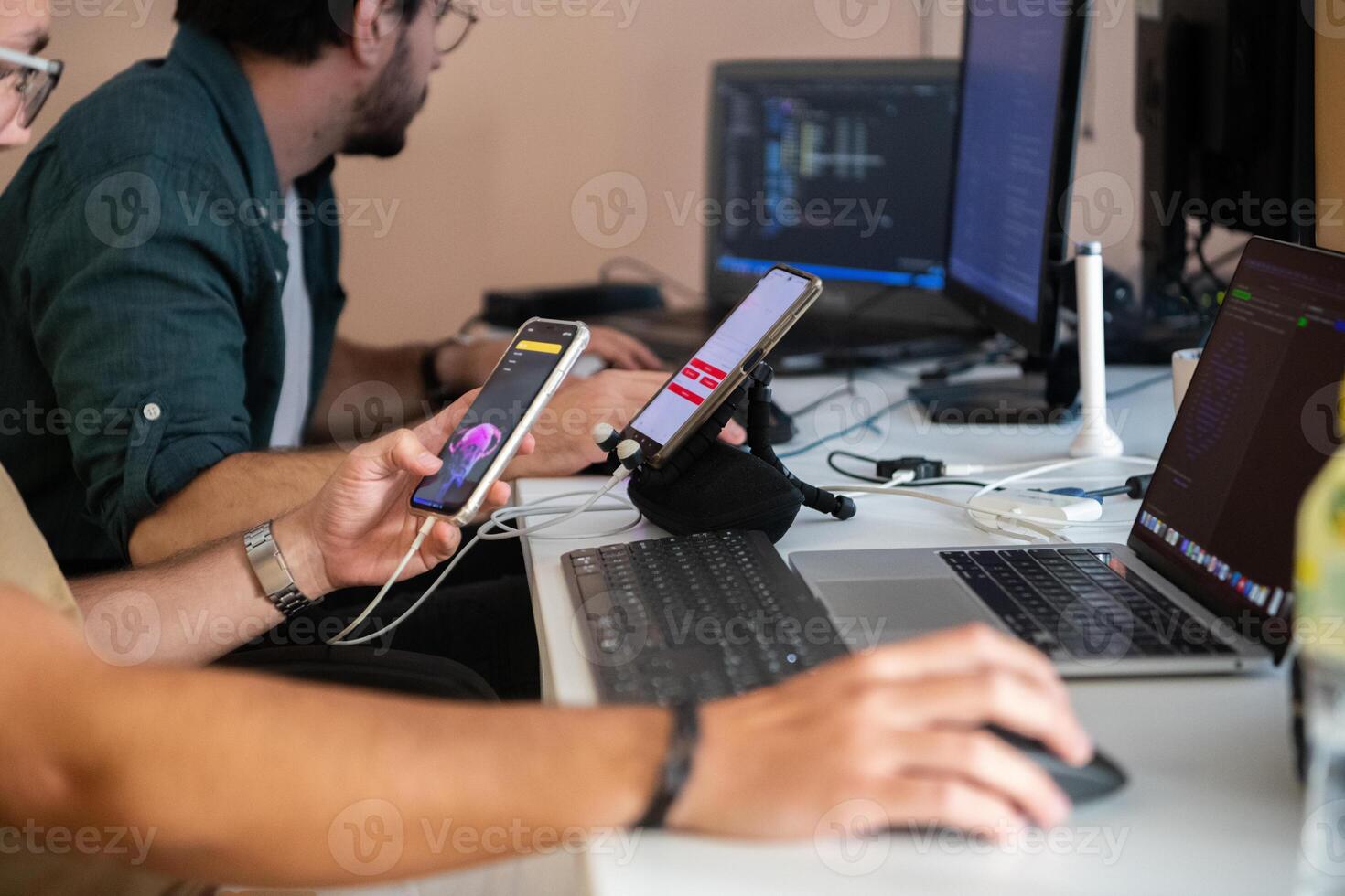 Programmers engrossed in deep collaboration, diligently working together to solve complex problems and develop innovative mobile applications with seamless functionality. photo