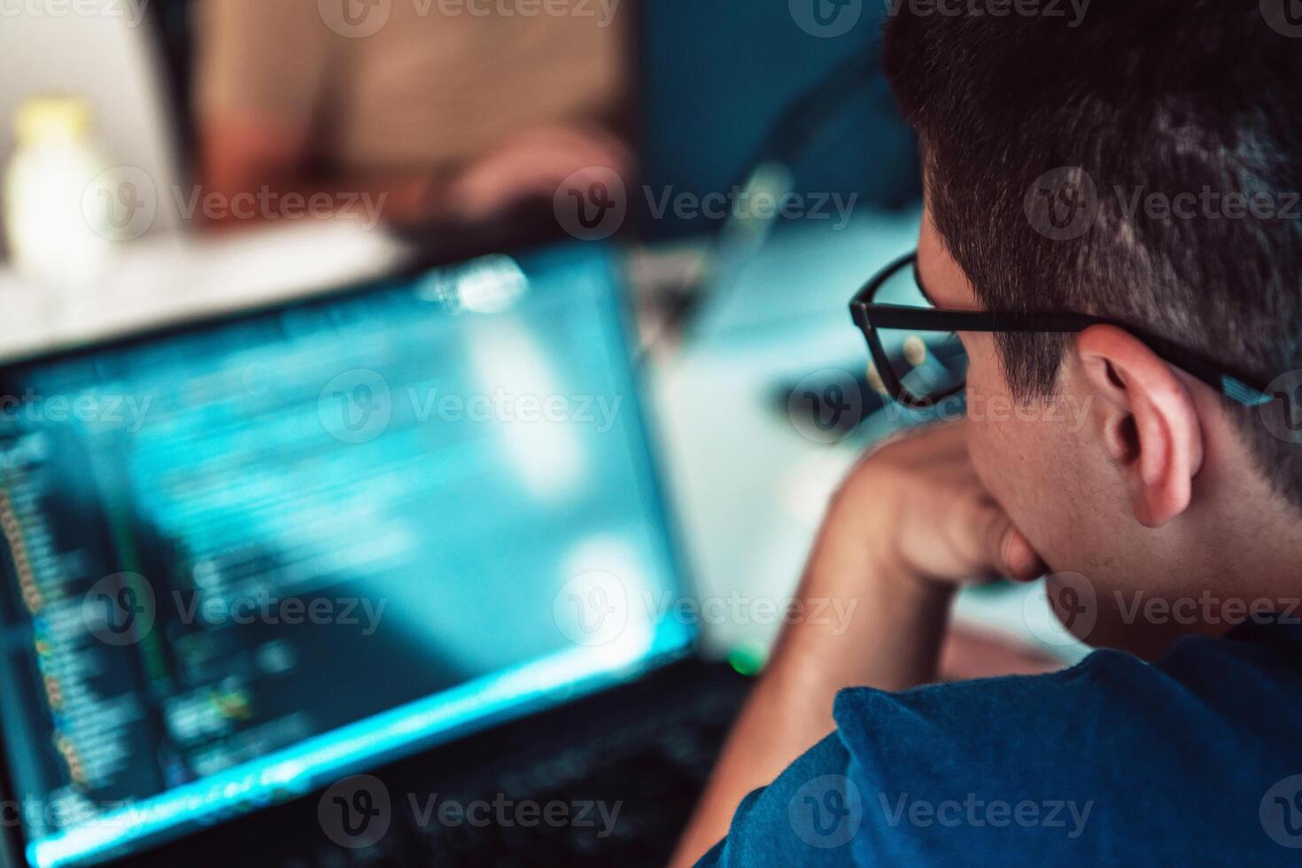 A programmer diligently testing smartphone applications while sitting in their office. photo