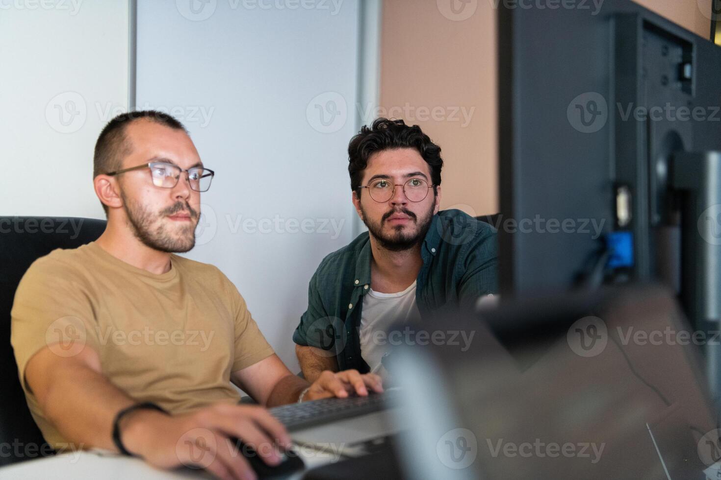 Programmers engrossed in deep collaboration, diligently working together to solve complex problems and develop innovative mobile applications with seamless functionality. photo