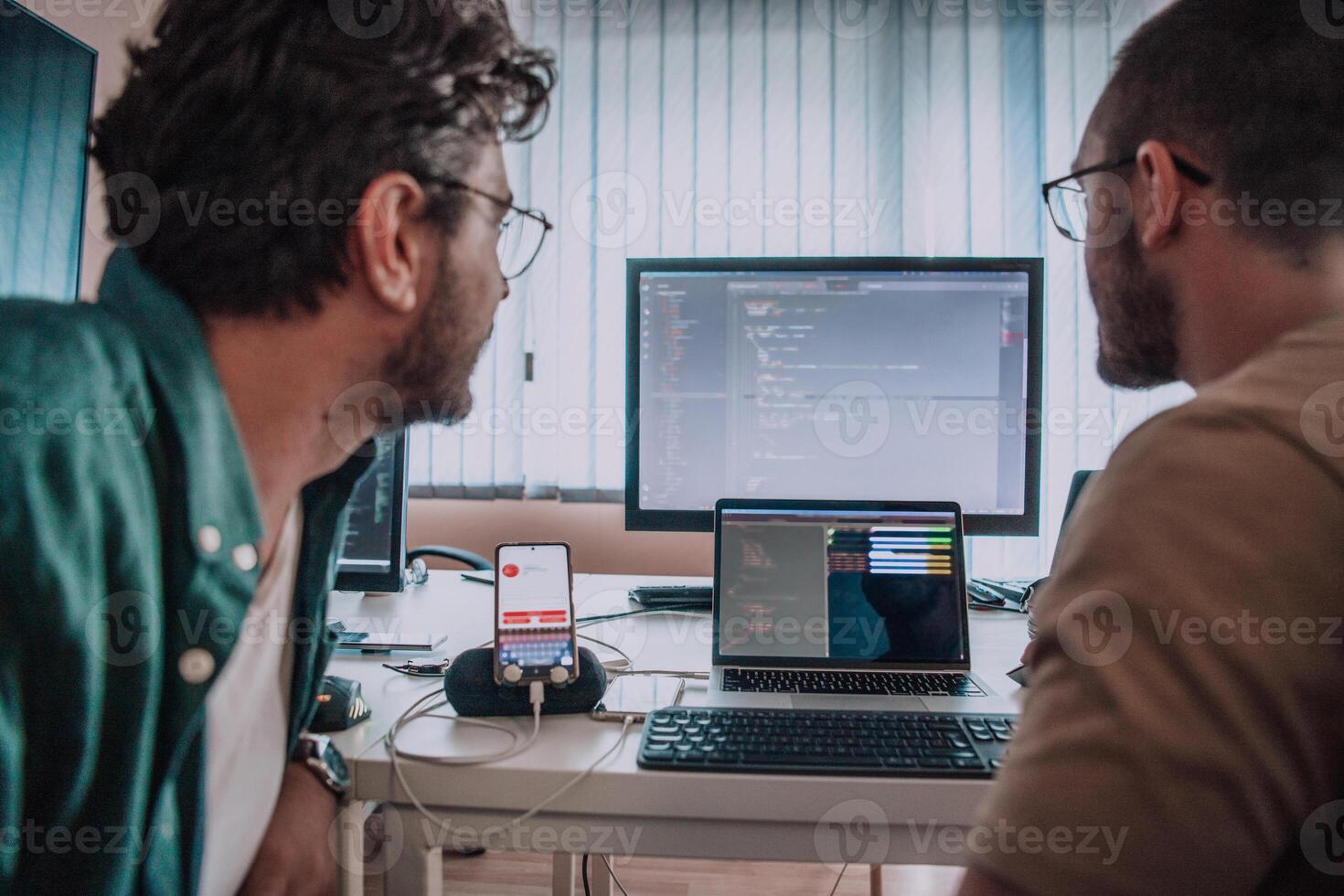 Programmers engrossed in deep collaboration, diligently working together to solve complex problems and develop innovative mobile applications with seamless functionality. photo