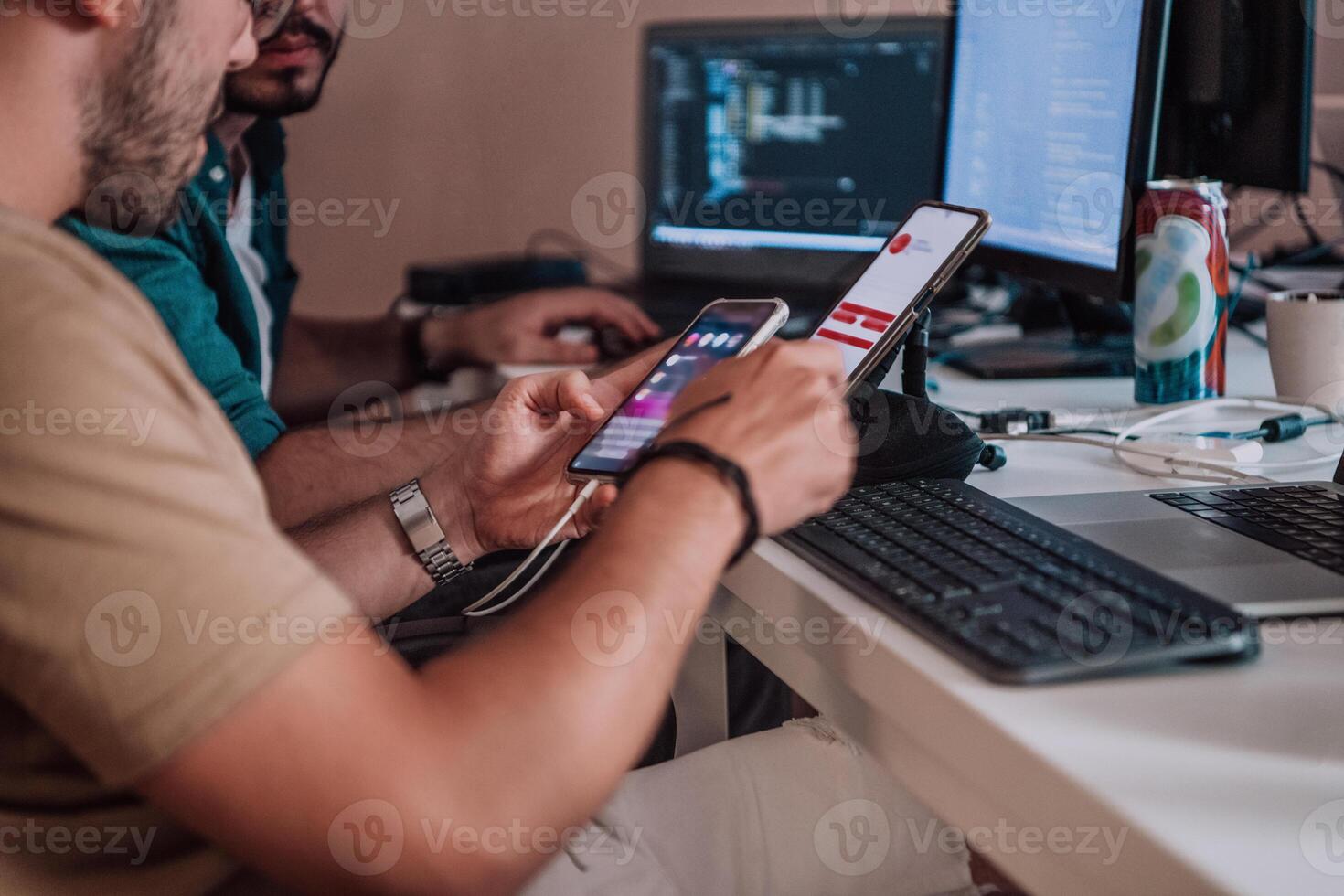 A programmer diligently testing smartphone applications while sitting in their office. photo