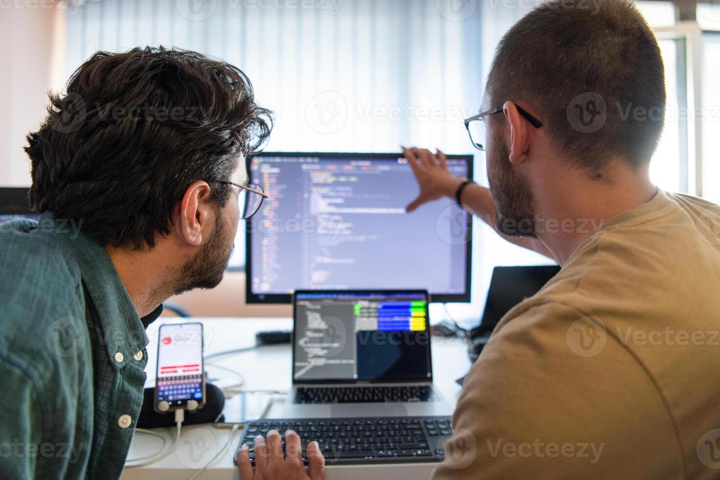 Programmers engrossed in deep collaboration, diligently working together to solve complex problems and develop innovative mobile applications with seamless functionality. photo
