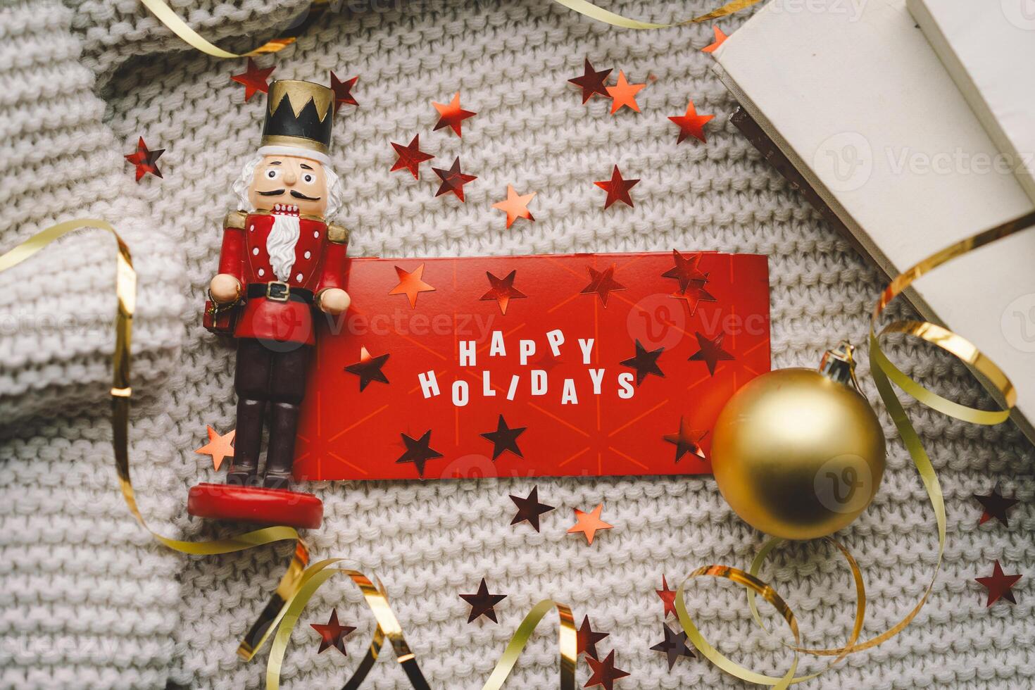 Festive holiday greeting with a nutcracker and decorations on a cozy knitted blanket photo