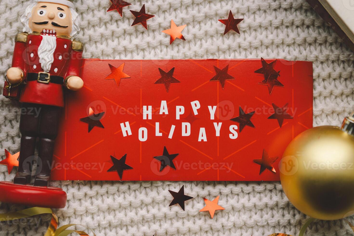 Festive holiday greeting with a nutcracker and decorations on a cozy knitted blanket photo