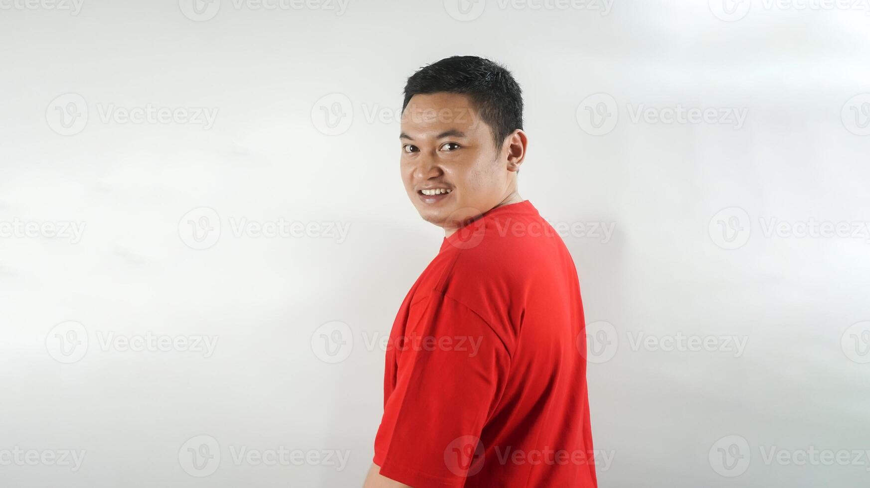 A young Indonesian man wearing a red t-shirt with a smiling face facing forward photo
