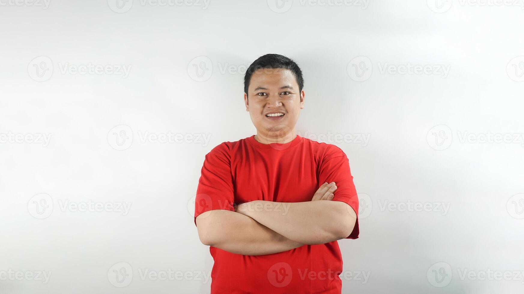 A young Indonesian man wearing a red t-shirt with a smiling face facing forward photo