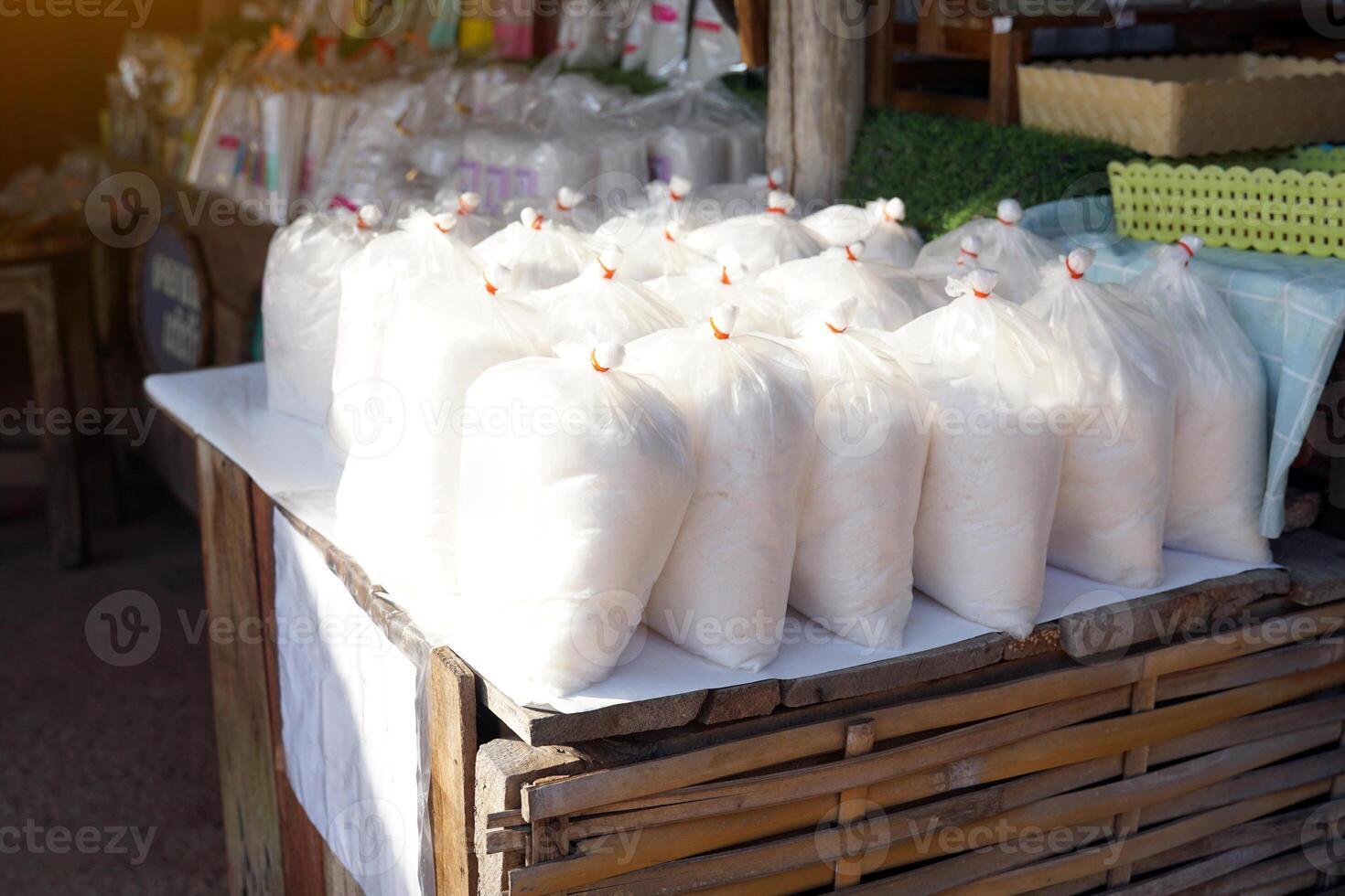 Bags of rock salt lined up on the tables of the community shop. photo