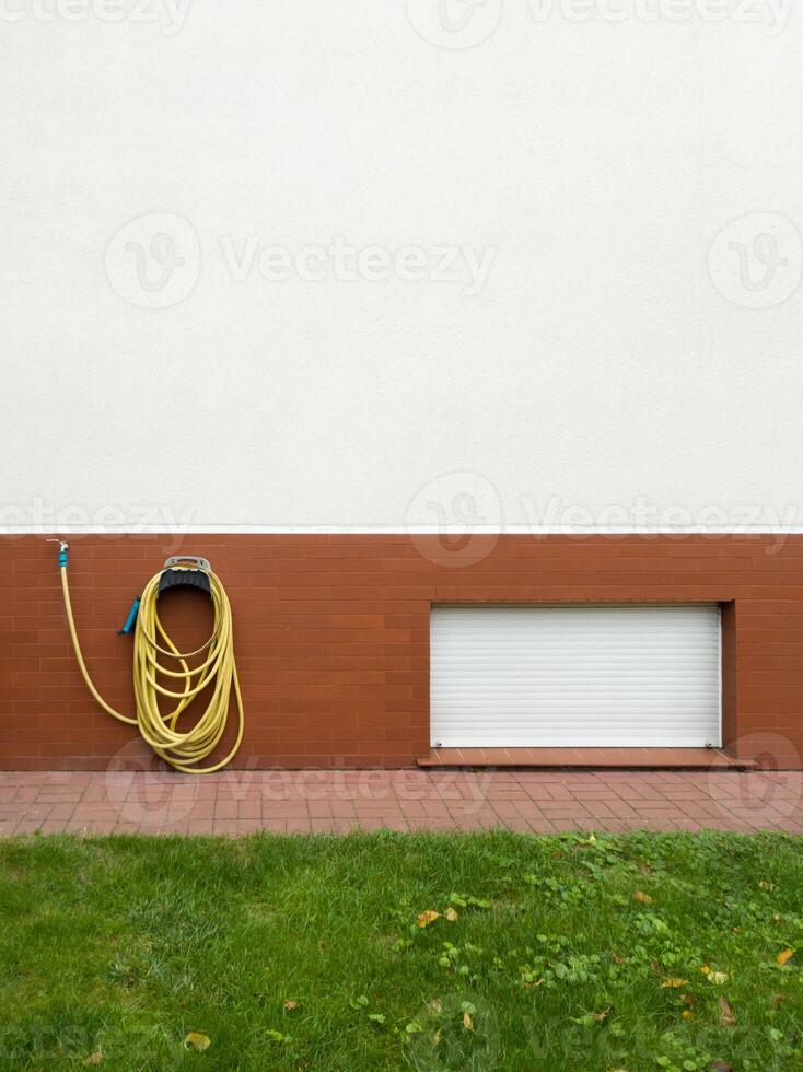 Garden Hose Hung on Brick Wall photo