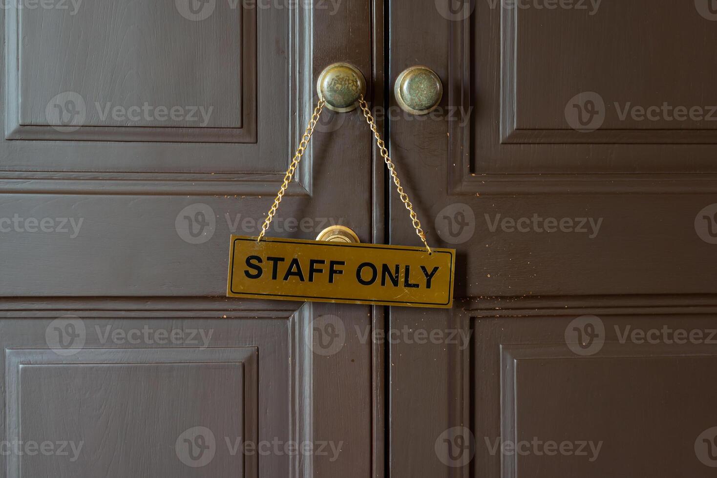 Staff only gold label hanging on knob in front of staff room photo