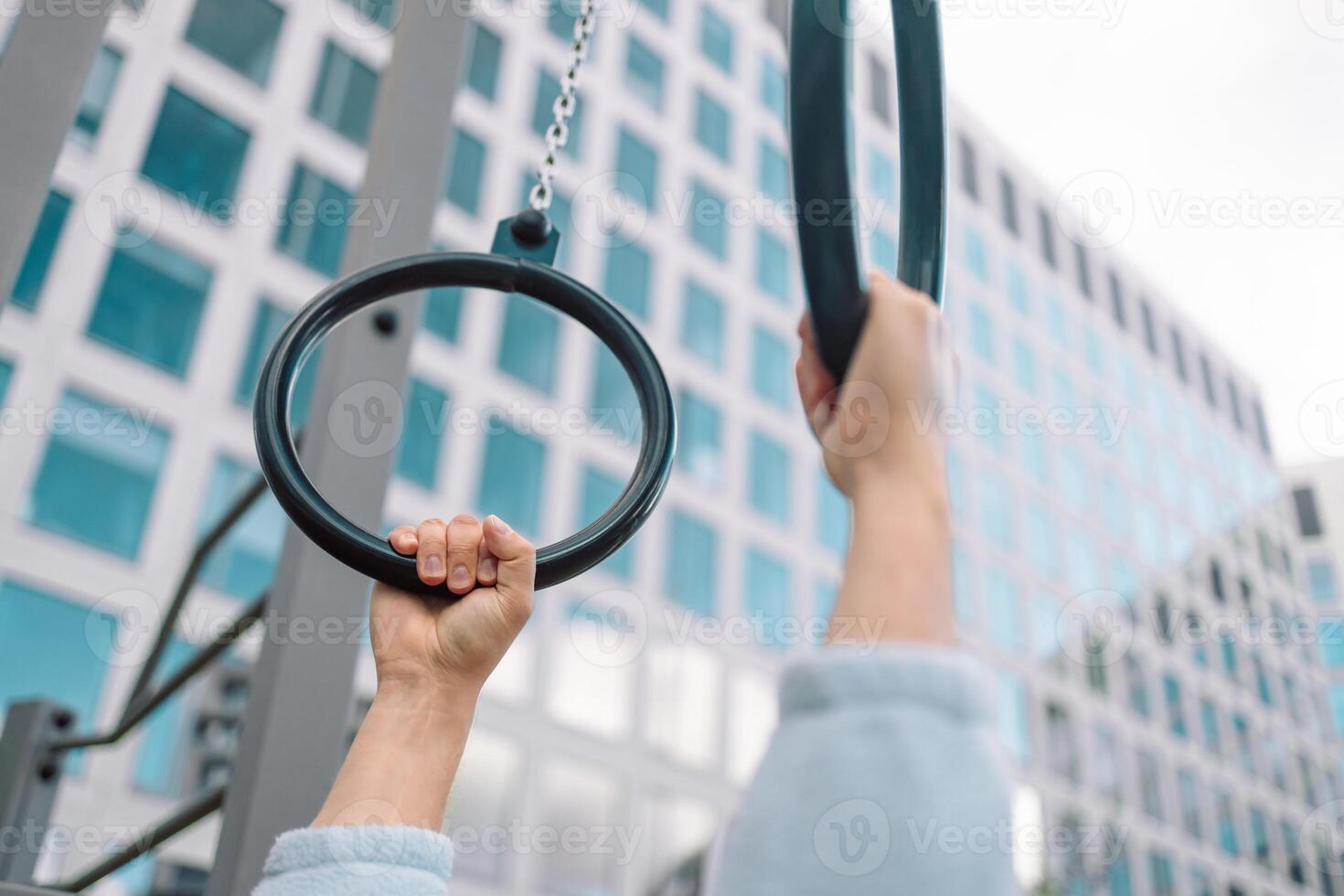 Hands, gymnastics ring and person in fitness for workout, strength training or competition. Closeup of hanging athlete, strong gymnast or acrobat holding on balance circles for performance exercise photo