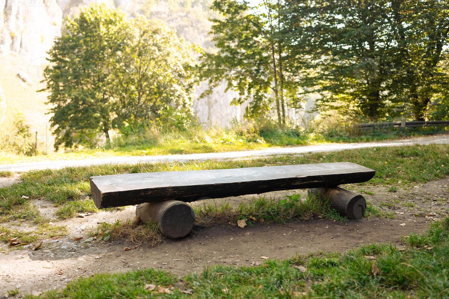 A bench for a halt in a national Ojcowski park with village. Rest place with wooden bench. Warm sunny weather. Beautiful nature. photo
