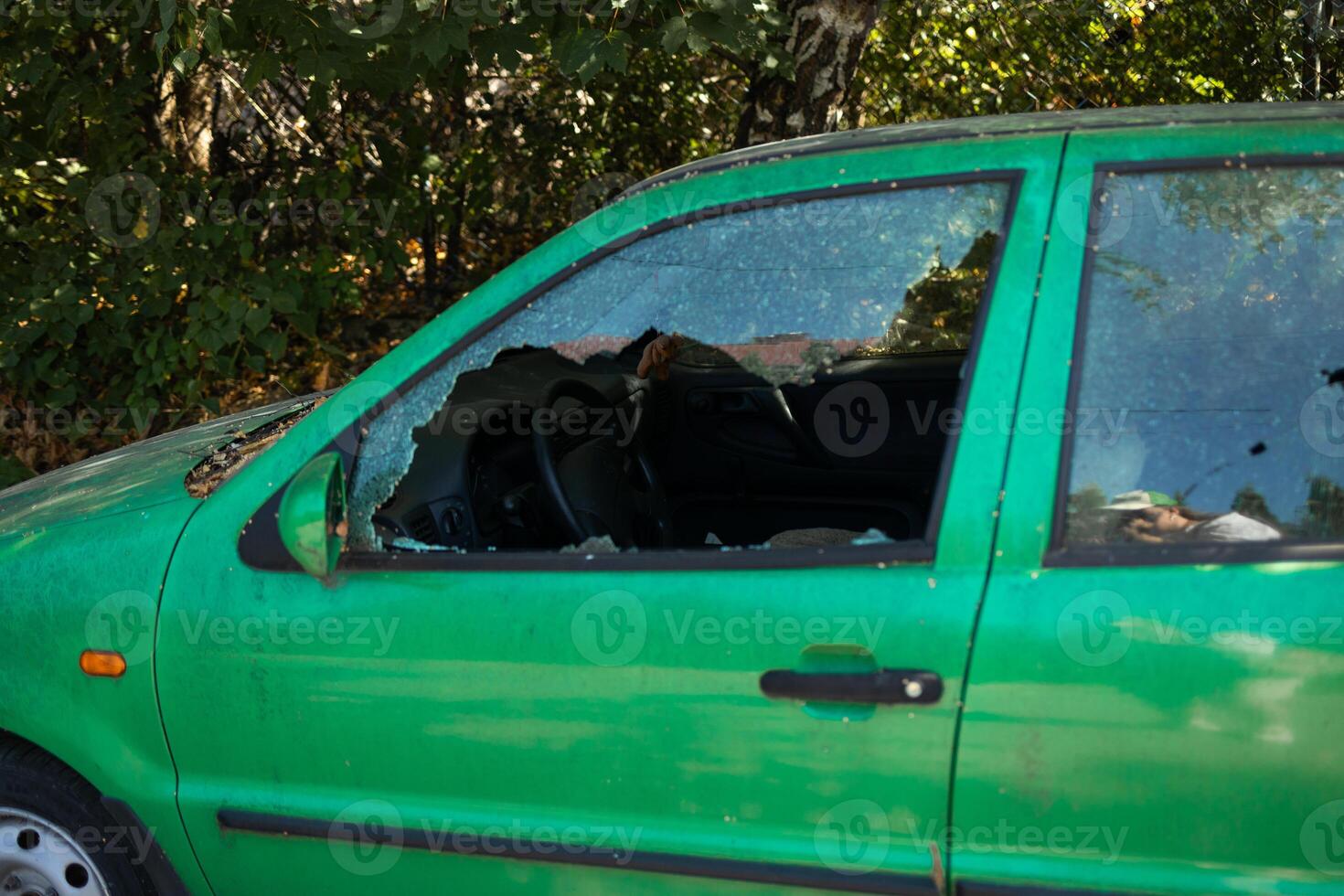 A criminal incident. Hacking the car. Broken left side window of a car photo