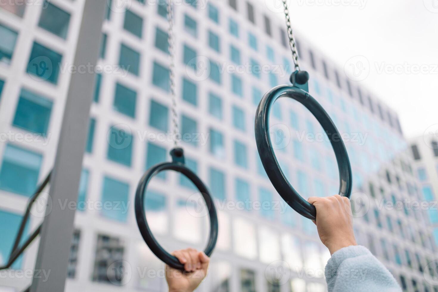 Hands, gymnastics ring and person in fitness for workout, strength training or competition. Closeup of hanging athlete, strong gymnast or acrobat holding on balance circles for performance exercise photo