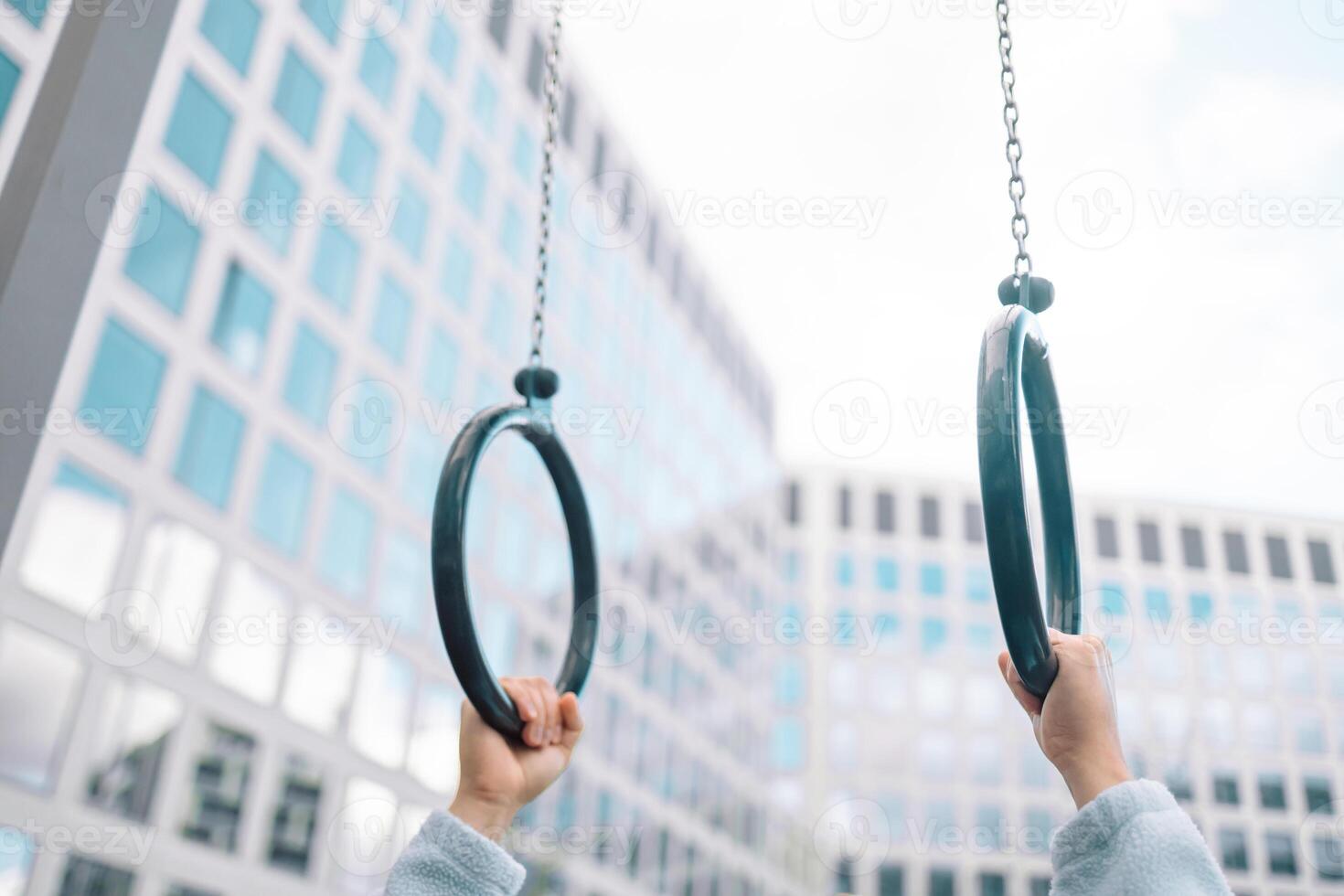 Hands, gymnastics ring and person in fitness for workout, strength training or competition. Closeup of hanging athlete, strong gymnast or acrobat holding on balance circles for performance exercise photo