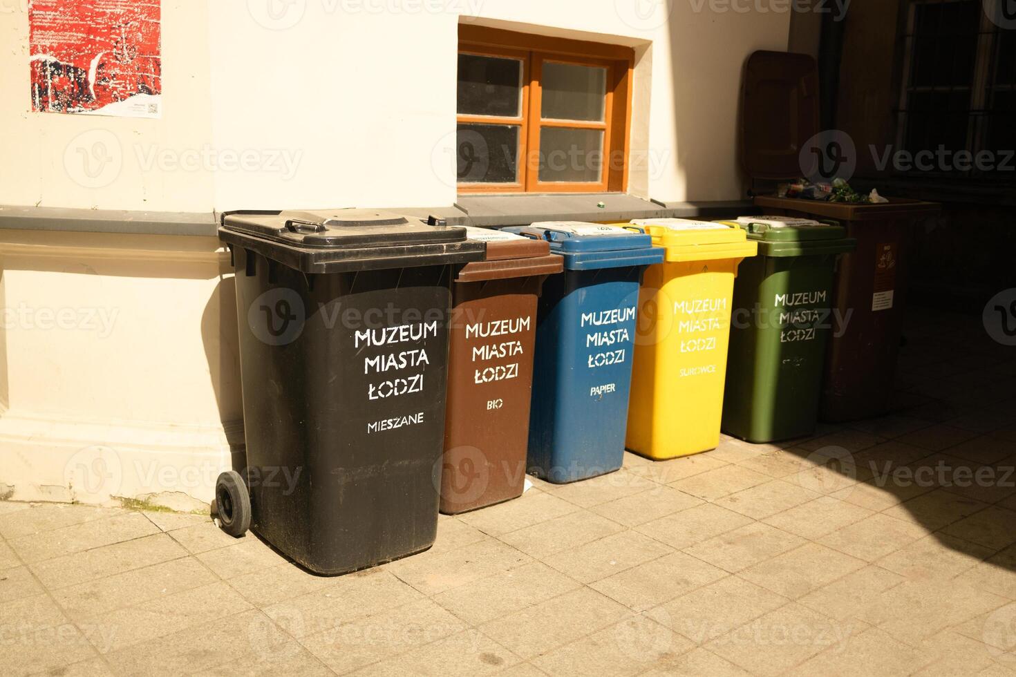 Plastic pollution problem. Large multi-colored garbage plastic bins for sorting garbage near a building on the street photo