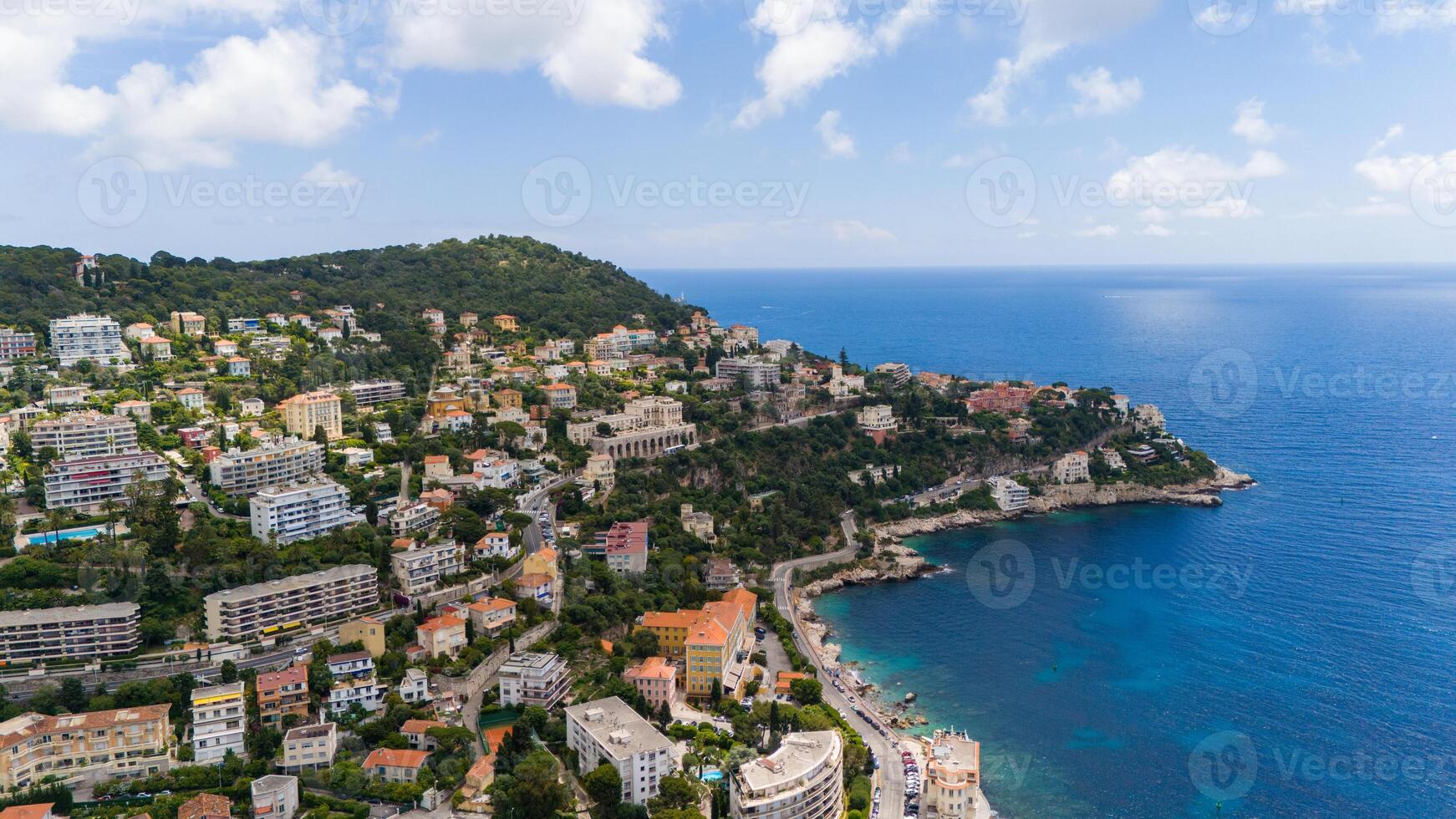 Aerial view of a scenic coastal area in the French Riviera, featuring hillside villas and lush greenery overlooking the clear blue waters of the Mediterranean Sea. Nice, France photo