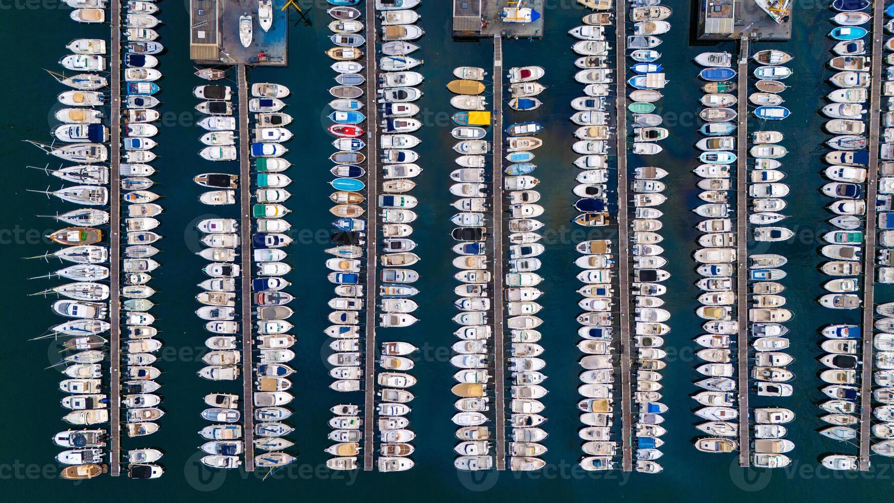 Aerial view of a marina filled with rows of docked boats, showcasing a stunning pattern of vessels against the deep blue water. Port of Marseille, France photo