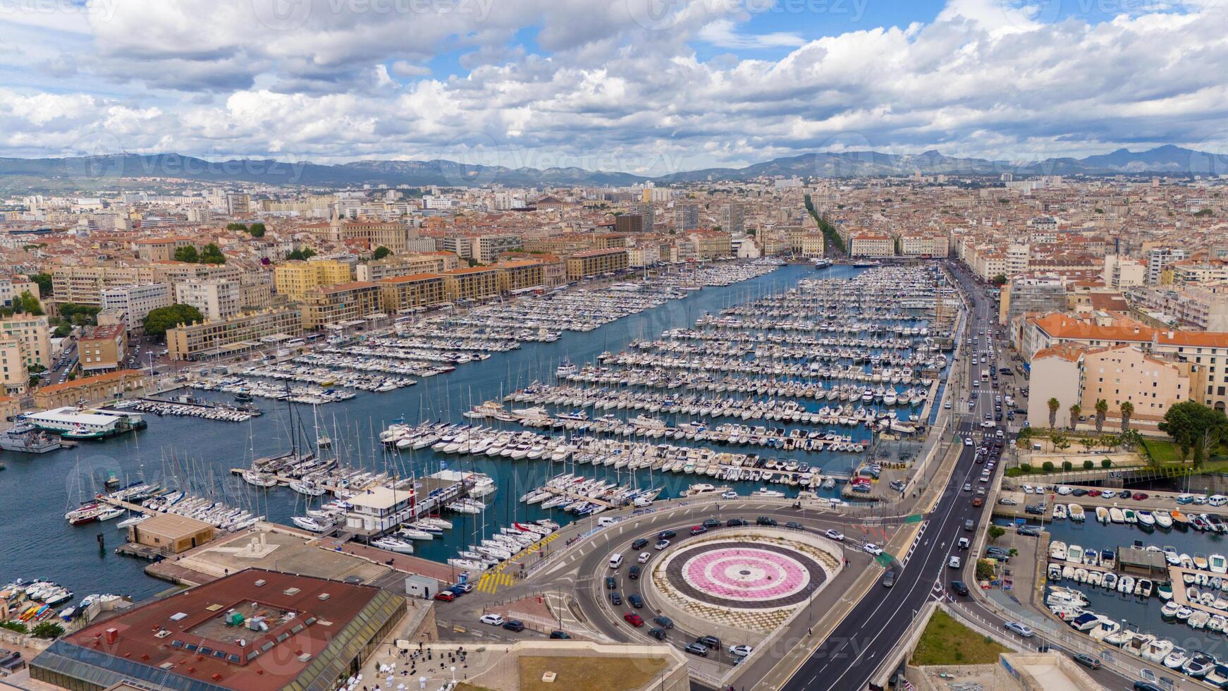 Aerial View of the Vieux-Port in Marseille, France, with Hundreds of Boats Docked, Surrounded by the City's Historic Buildings and Scenic Hills in the Background photo