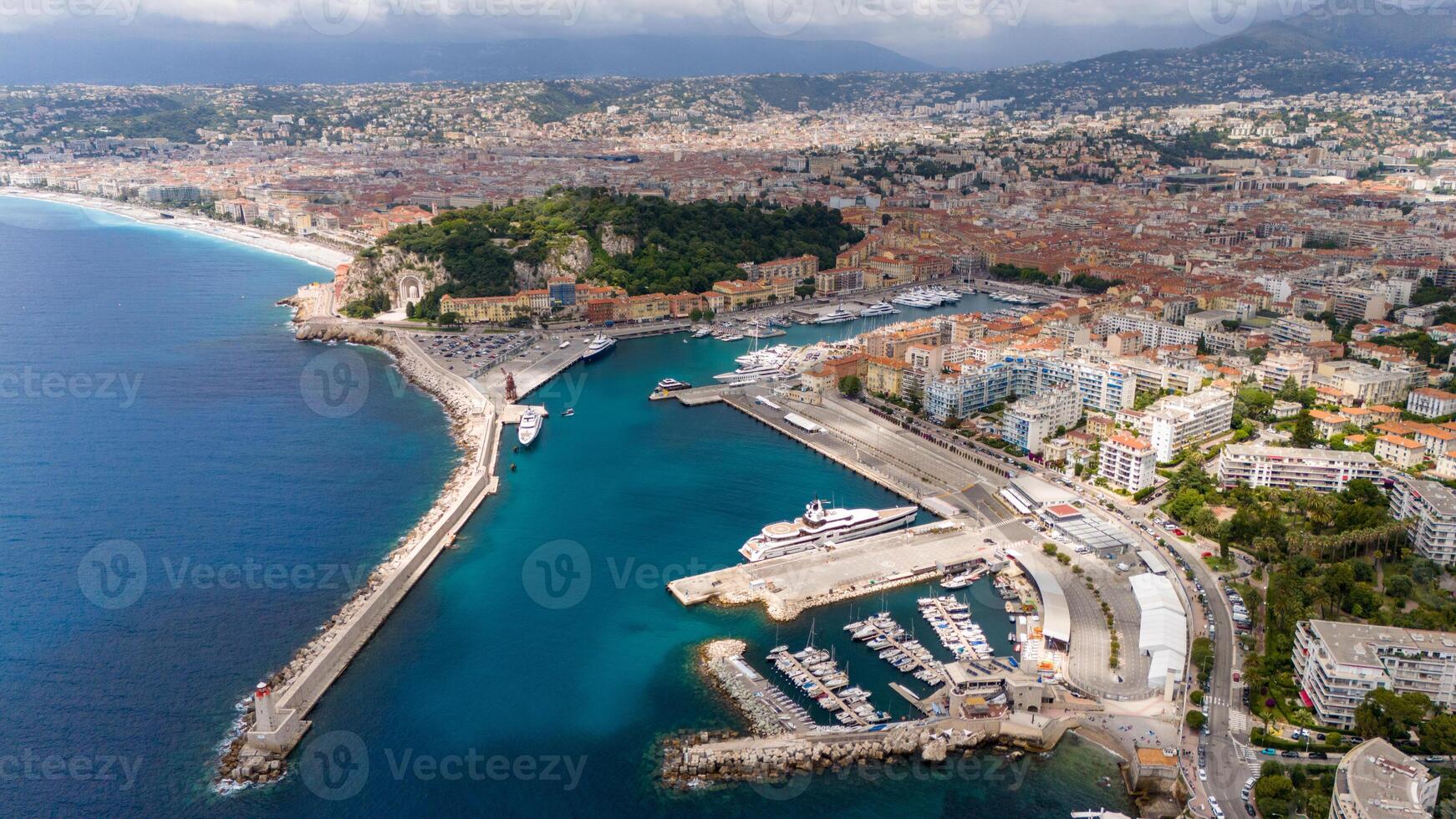 Aerial view of Nice, France, featuring the stunning coastline with turquoise waters, the bustling port filled with yachts, and the vibrant cityscape stretching along the Mediterranean. photo