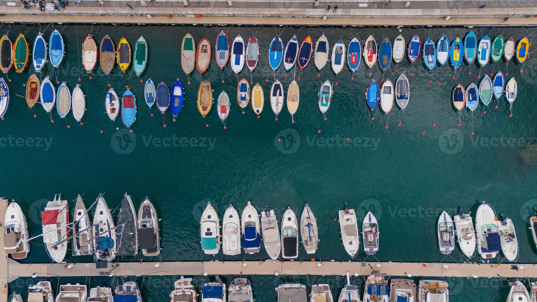 Aerial view of colorful boats docked in a marina, showcasing a vibrant array of vessels floating on clear blue waters. Nice, France photo