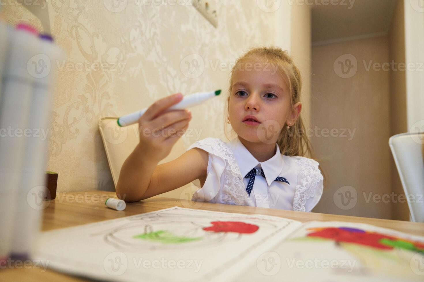 Young girl engaged in creative coloring activity at home during day photo