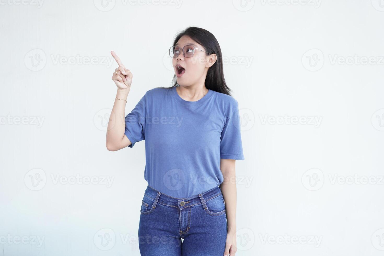 Beautiful Asian woman looks shocked, with a 'wow' expression, pointing to the side with her forefinger photo