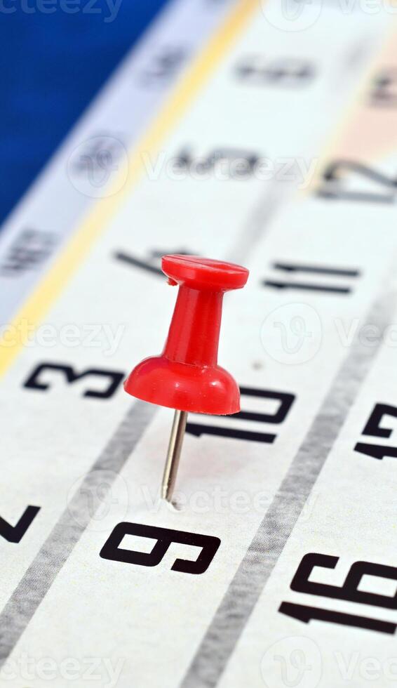 pushpin on a calendar date, reminder and time concept photo
