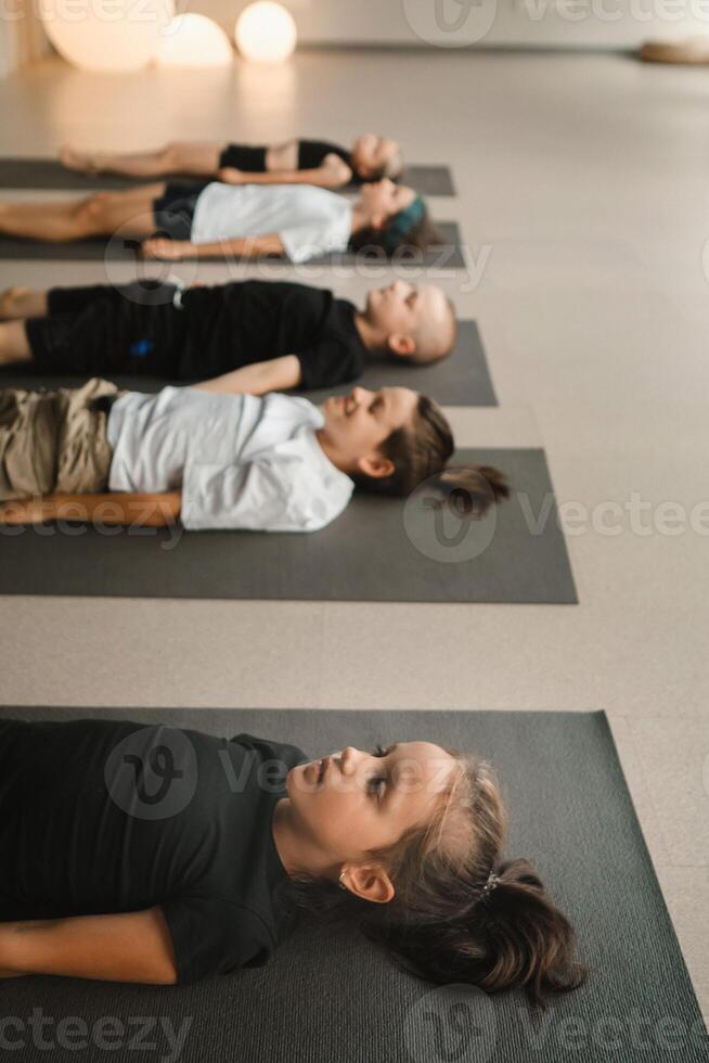 Children lying on the floor relax to the sounds of a Tibetan bowl. Children's yoga photo
