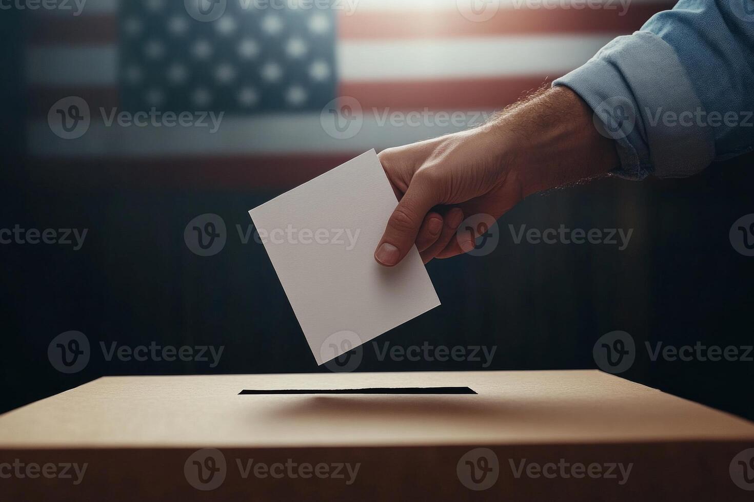 A close-up of a hand placing a ballot into a voting box against an American flag backdrop photo