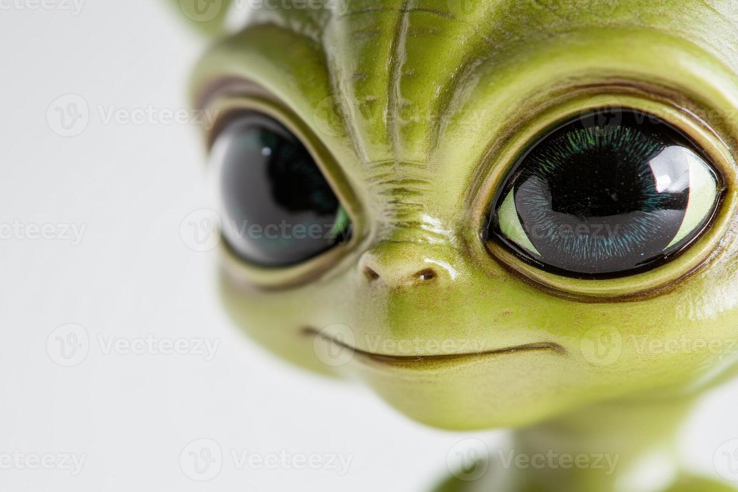 Close-up of a cute alien character with big eyes and vibrant green skin against a white background photo