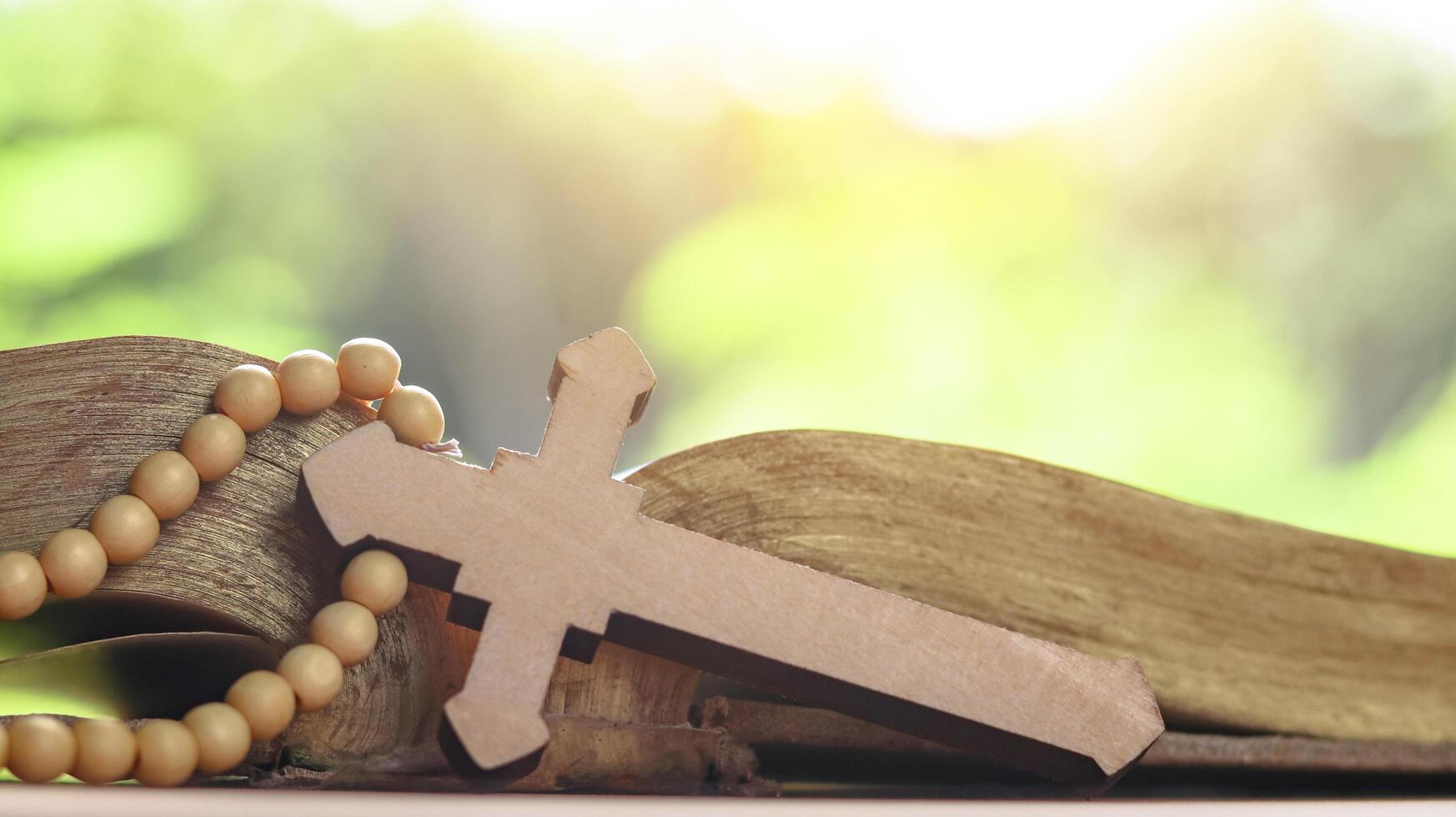 Brown wooden cross on an old open book symbolizing the spread of Jesus Christs love among Christians reflecting faith devotion and the importance of Christian teachings. photo