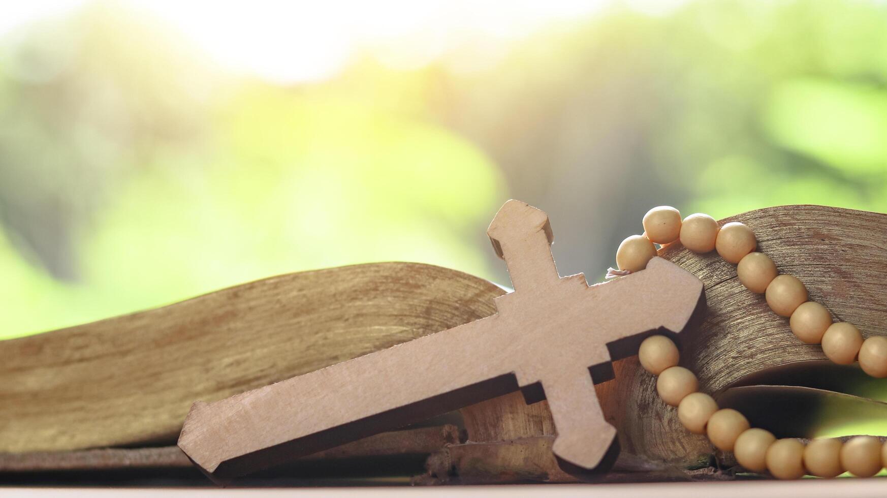 Brown wooden cross on an old open book symbolizing the spread of Jesus Christs love among Christians reflecting faith devotion and the importance of Christian teachings. photo