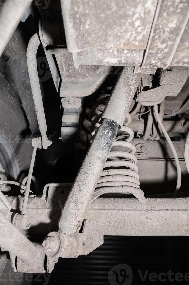 Close-up view from under the car. Dirty suspension of an off-road vehicle. Transmission components photo