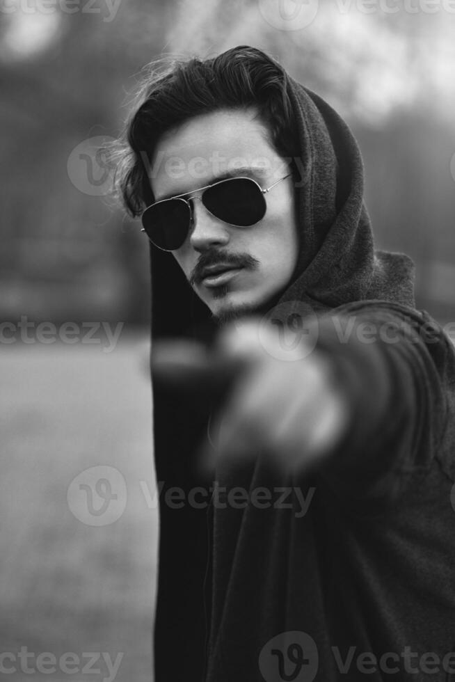 The guy points his finger at the camera, calling for action. photo