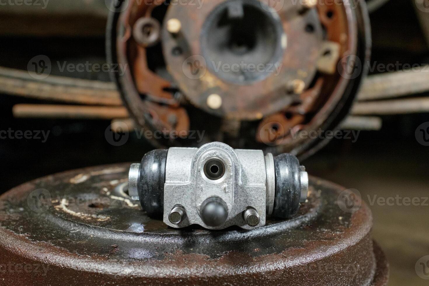 New car brake slave cylinder.The mechanic is repairing the car brake system.Old car parts on the table in the workshop. Selective focus. photo