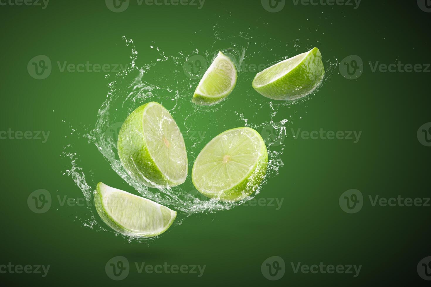 Water splashing on Fresh green lime and leaves isolated on a green background photo