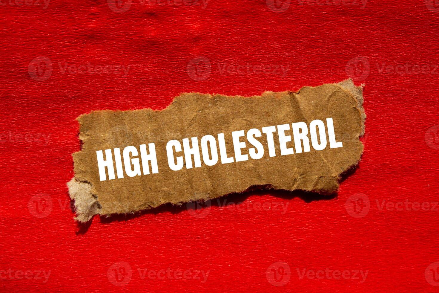 High cholesterol message written on ripped torn cardbaord paper piece with red background. Conceptual high cholesterol symbol. Copy space. photo