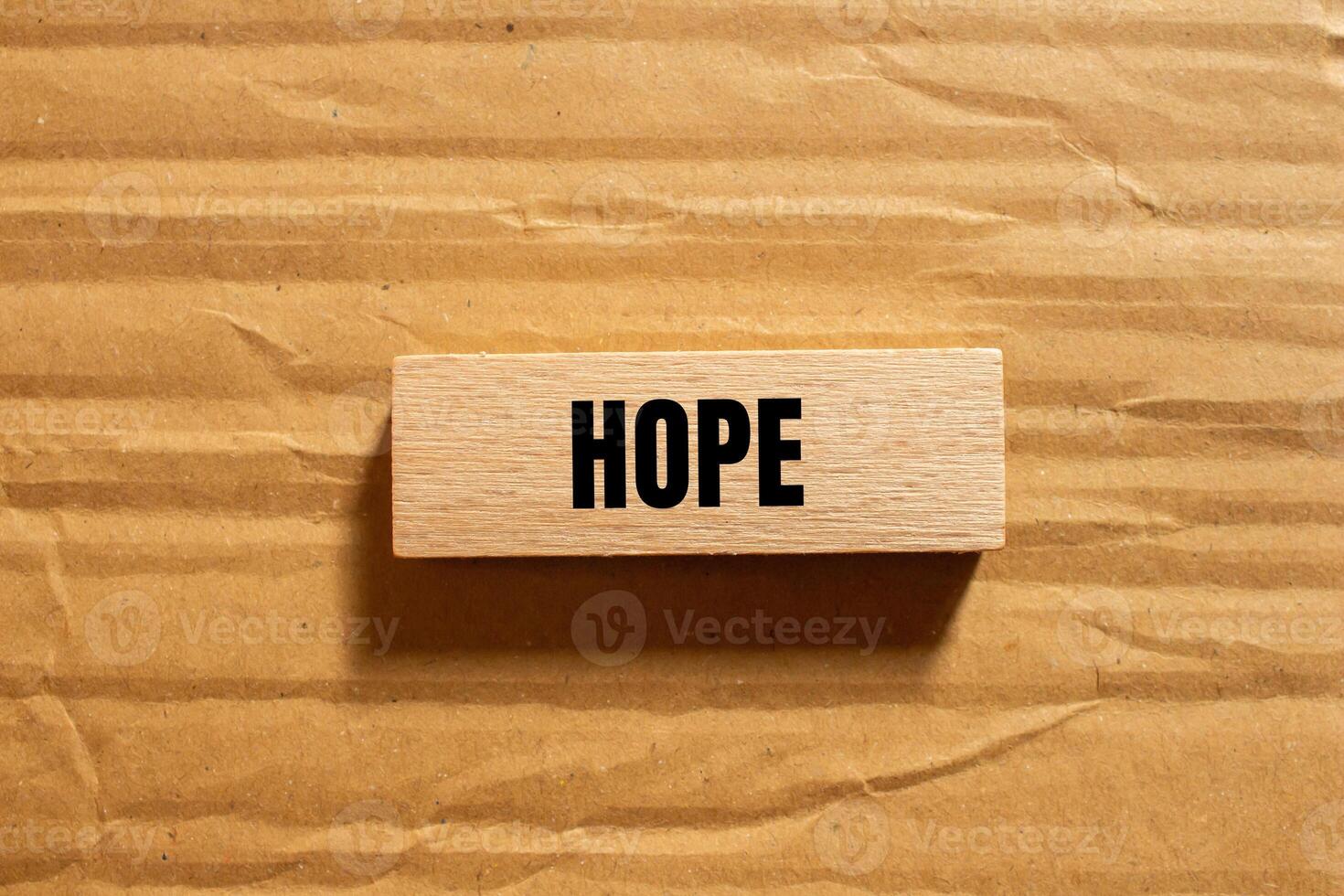 Hope message written on wooden block with cardboard background. Conceptual hope symbol. Copy space. photo