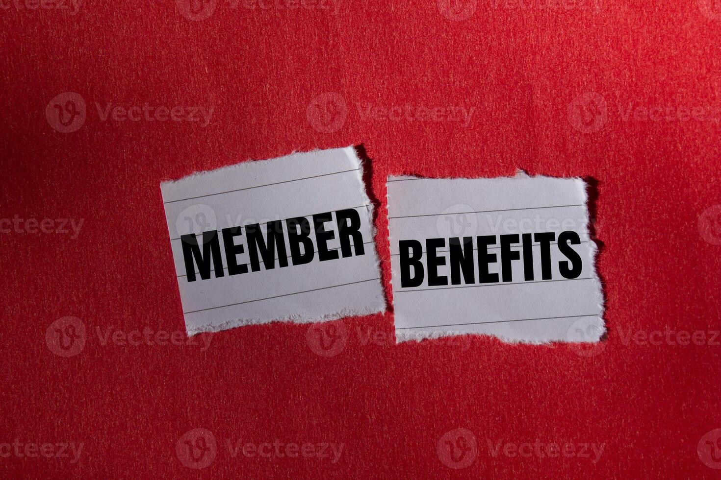 Member benefits message written on ripped torn paper piece with red background. Conceptual member benefits symbol. Copy space. photo