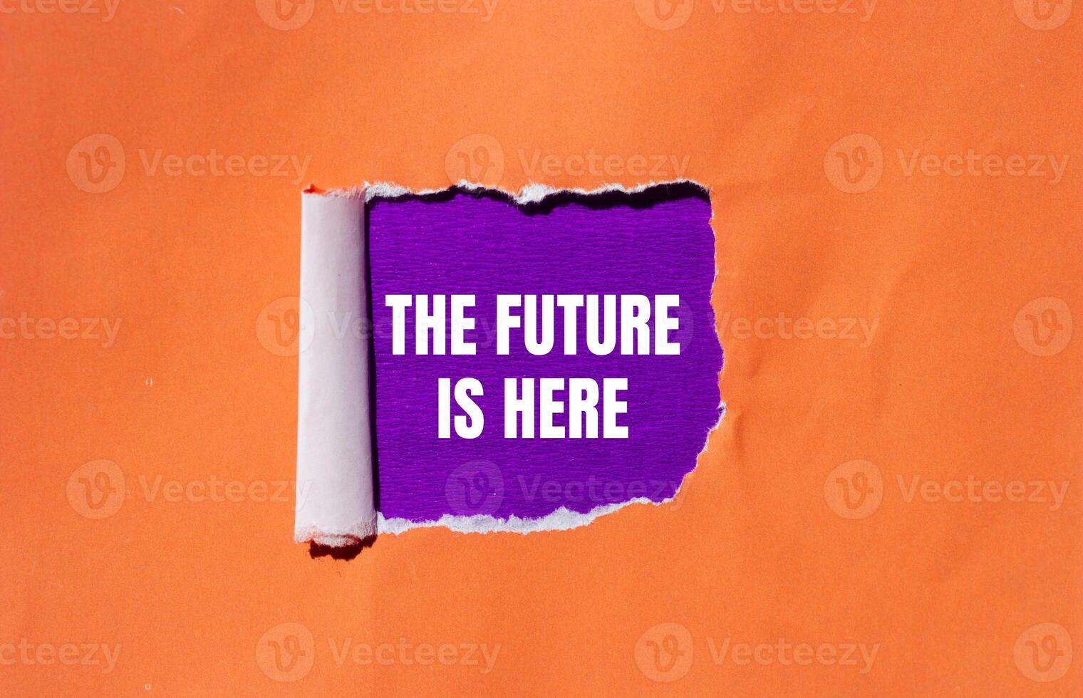 The future is here message written on ripped torn orange paper with purple background. Conceptual the future is here symbol. Copy space. photo