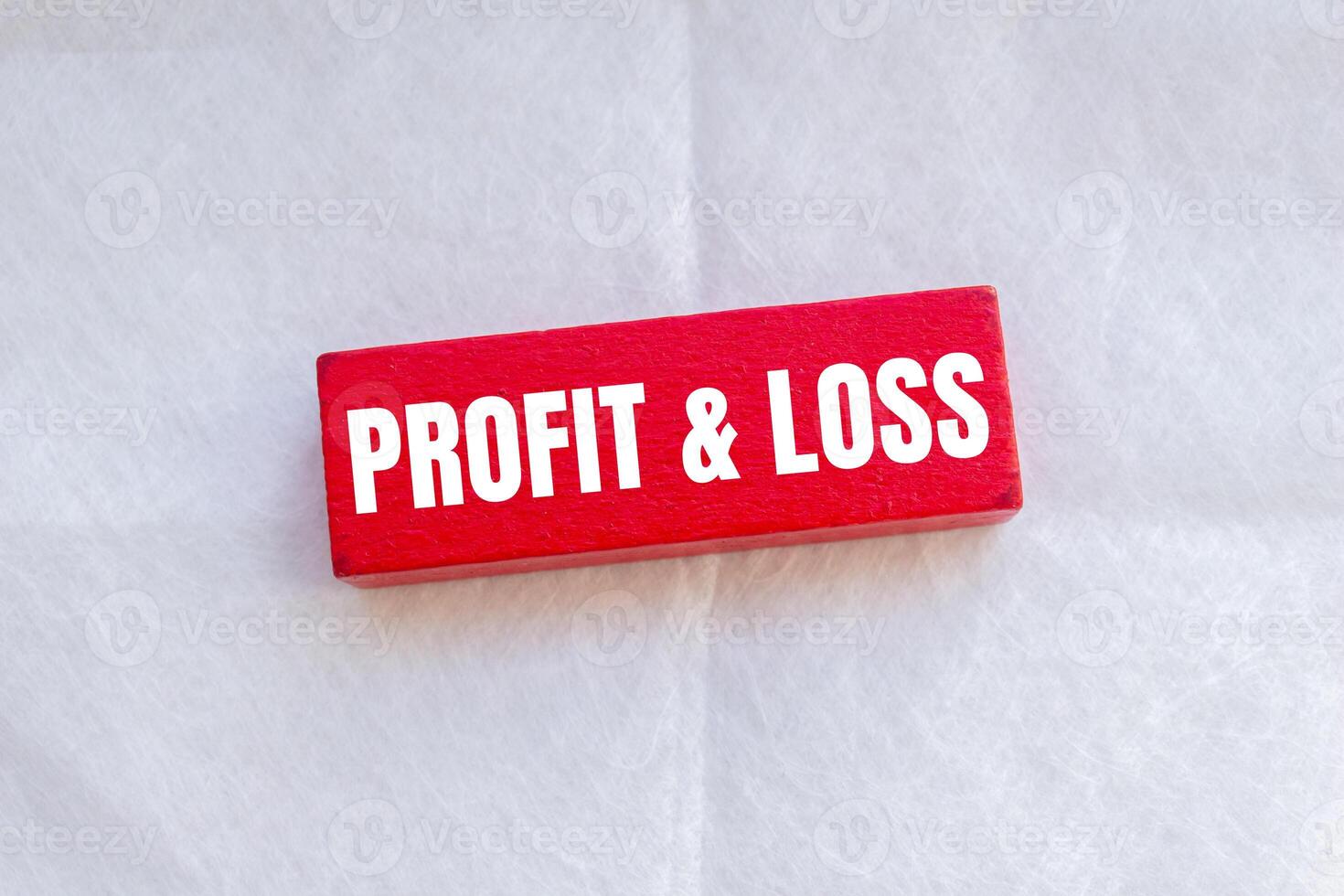 Profit and loss message written on red wooden block with white background. Conceptual profit and loss symbol. Copy space. photo